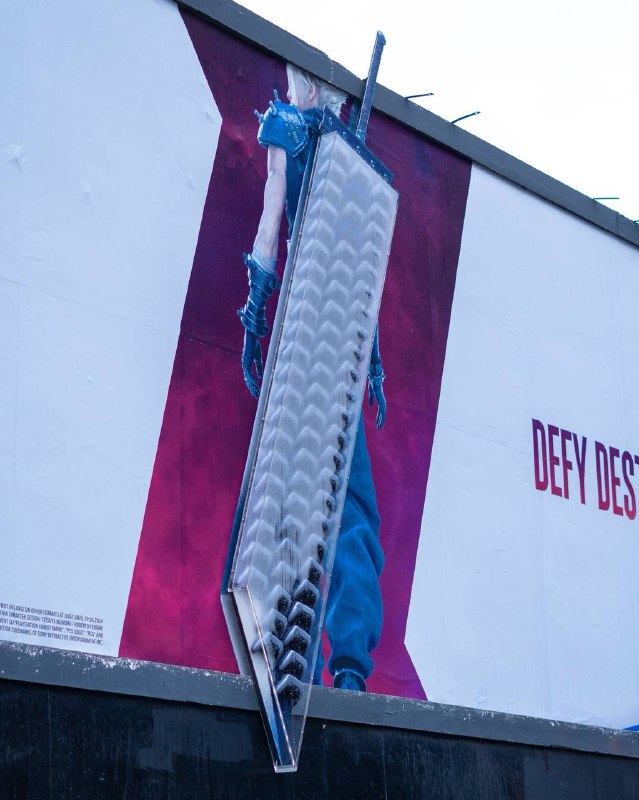 《最终幻想 7 重生》在英国伯明翰街头投放的巨型广告，克劳德标志性的破坏剑由 DualSense 无线手柄组成，在UK的阴雨天气下更加符合游戏的气质了